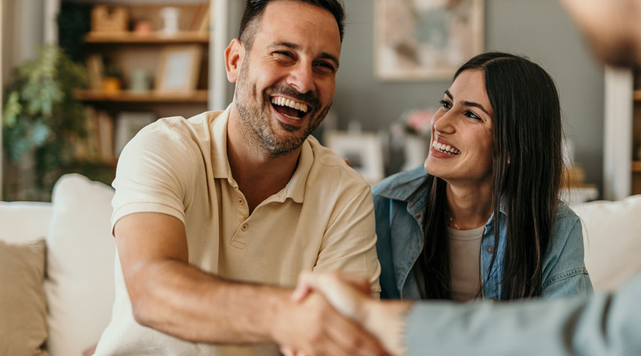 Couple Smiling Shaking Hands with Insurance Agent